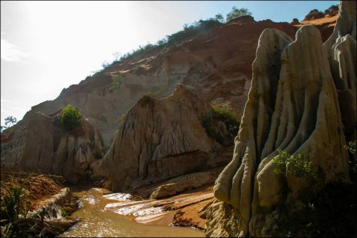 wading through red river surrounded by red canyons wading through red river surrounded by red canyons